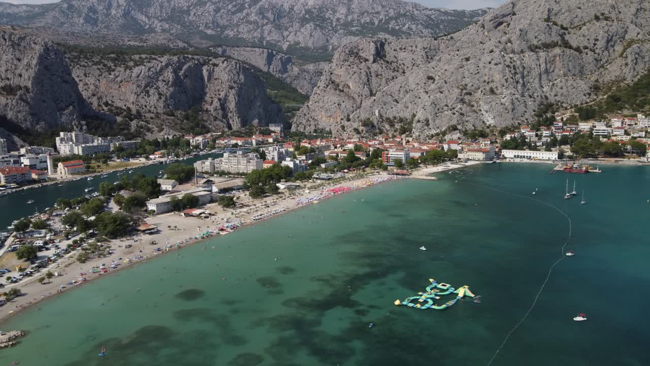 Panoramic aerial view of Velika Plaza beach in Omis between the Cetina River and the Adriatic Sea divided by scenic hills