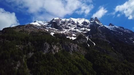 sliding drone shot of slovenian mountains, on a sunny day with some clouds