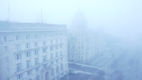 thick dense ghostly fog cover across liverpool city aerial view of surreal downtown waterfront descent forwards