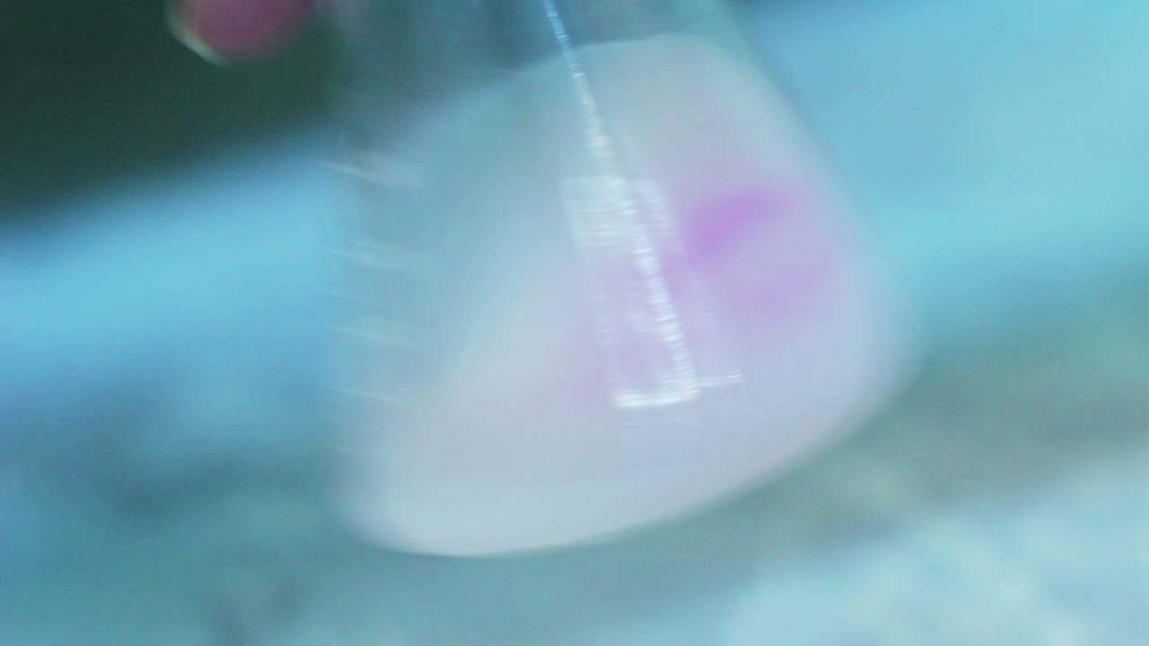 플라스크에 있는 화학 반응. 플라스크에 있는 액체를 흔드는 것. 실험실 연구