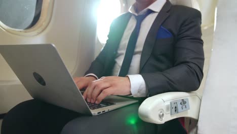 joven empresario que usa una computadora portátil en un avión