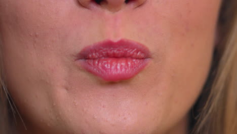 primer plano extremo de la boca de una mujer, modelo sacando la lengua y pasándola por los labios