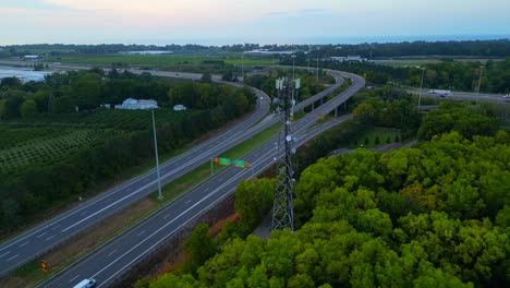 Orbital-aerial-view-of-cell-phone-tower-reveals-farmland-beyond-the-highway