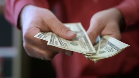 man counting dollar bills. close up of male hands count money cash