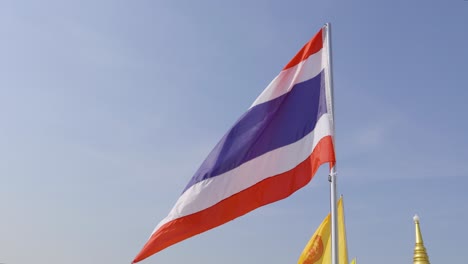 slow motion tilt down from thai flag to bangkok panorama