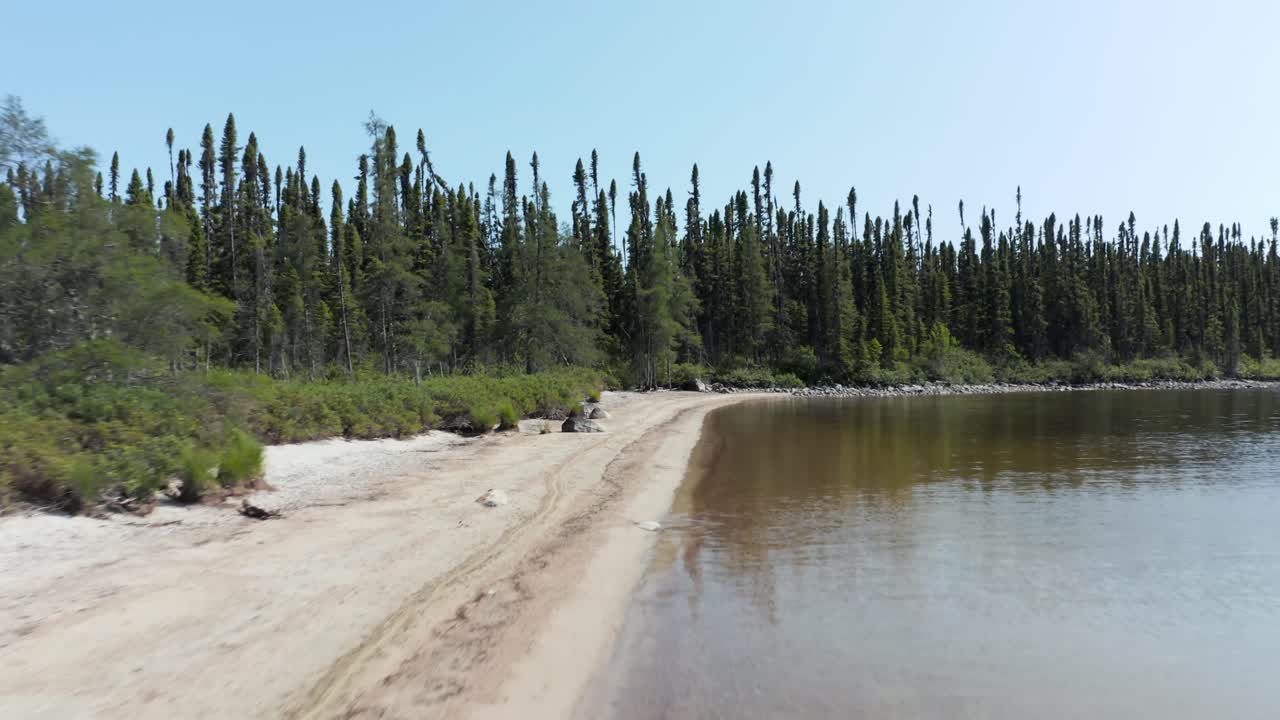 drone volando hacia atrás sobre una playa en un día soleado de verano