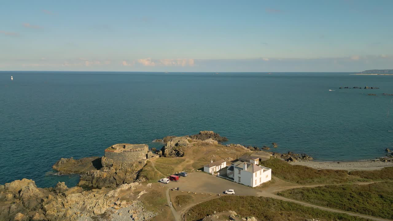 corto en vuelo sobre fort doyle guernsey hacia el mar mostrando la costa escarpada, páramos, fortaleza histórica y vistas a través de la punta de herm y hacia el mar en un día tranquilo y soleado