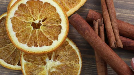 dried oranges with cinnamon on a wooden background