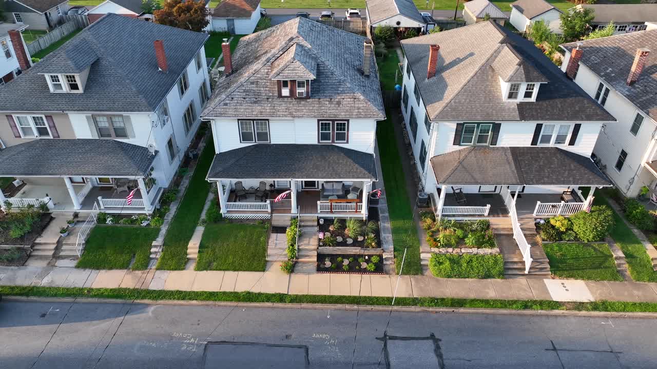 disparo de drones de alto ángulo de casas de pueblo en una ciudad estadounidense con banderas de ee.uu. ondeando en los porches