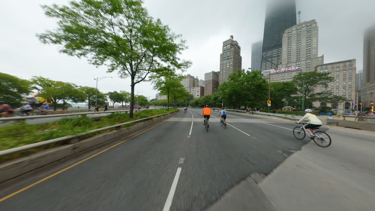 Chicago cyclists riding southbound on DuSable Lake Shore Drive during Bike the Drive 2022 biking past john hancock tower center michigan avenue magnificent mile oak street beach skyscraper clouds