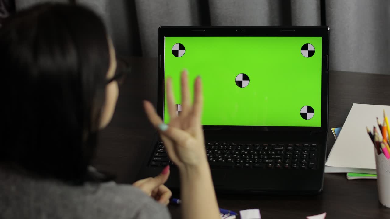 maestra haciendo llamada de video de educación a distancia en línea en la pantalla verde de la computadora portátil