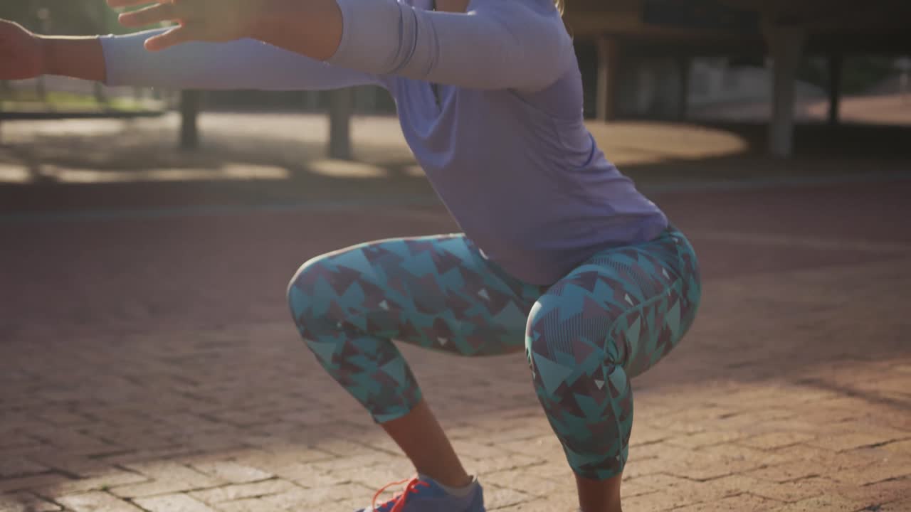 Donna caucasica che fa squat in un parco
