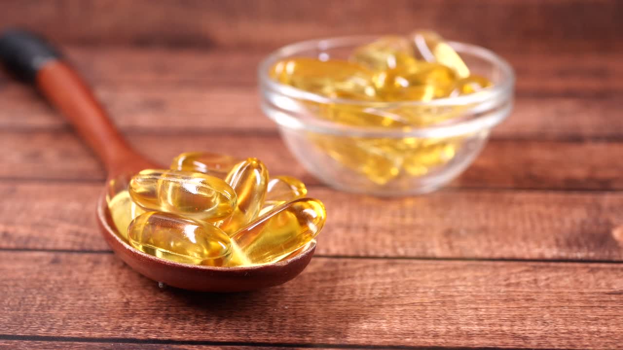 Golden Omega 3 Fish Oil Capsules on a Wooden Spoon