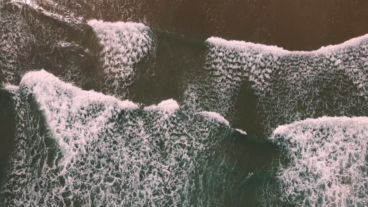 Experience the hypnotic motion of ocean waves from a breathtaking cenital aerial view