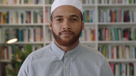 Un-Joven-Confiado-Del-Medio-Oriente-Parado-En-La-Biblioteca-Mirando-Un-Retrato-Sonriente-De-Un-Orgulloso-Empresario