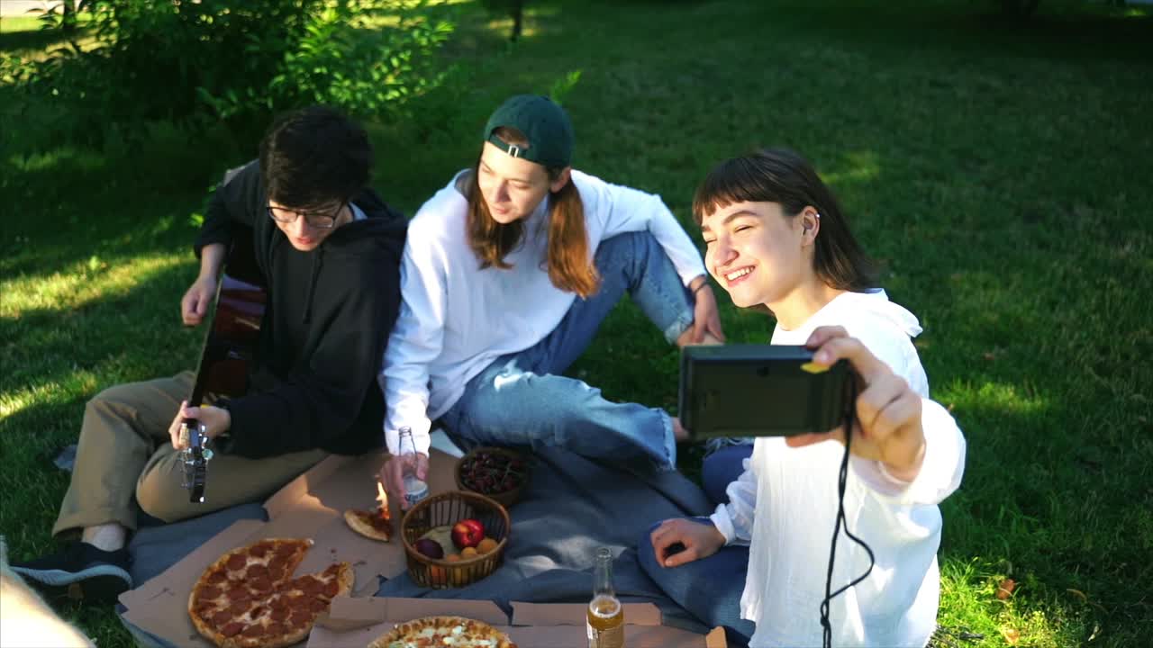 친구 들 이 공원 에서 피크닉 을 즐기고 있다