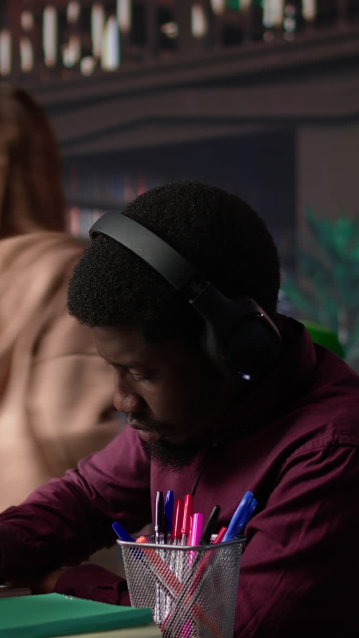 Vertical video african american guy uses ambient focus music to help with school assignment
