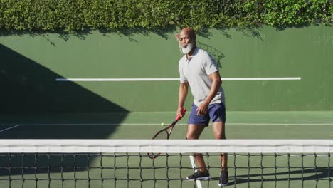 Afroamerikanischer-älterer-Mann,-Der-An-Einem-Strahlend-Sonnigen-Tag-Tennis-Auf-Dem-Tennisplatz-Spielt