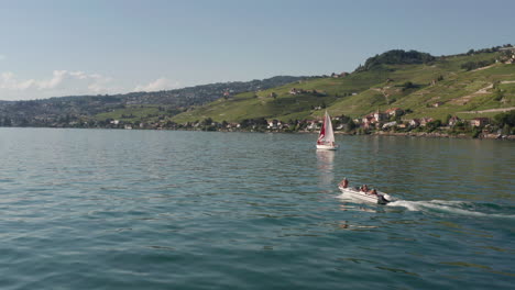 flying towards small motorboat driving over lake geneva