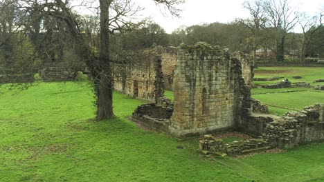 basingwerk abbey landmark medieval abandoned welsh ruins aerial view low left fly past