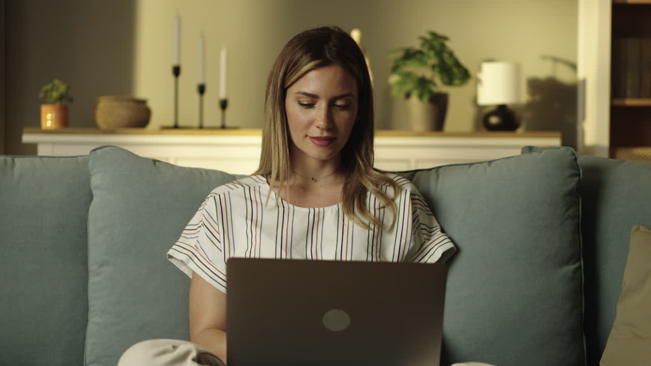 Woman using laptop on couch at home