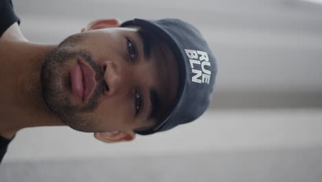 vertical: closeup of man modelling trendy new clothing brand cap, high-fashion