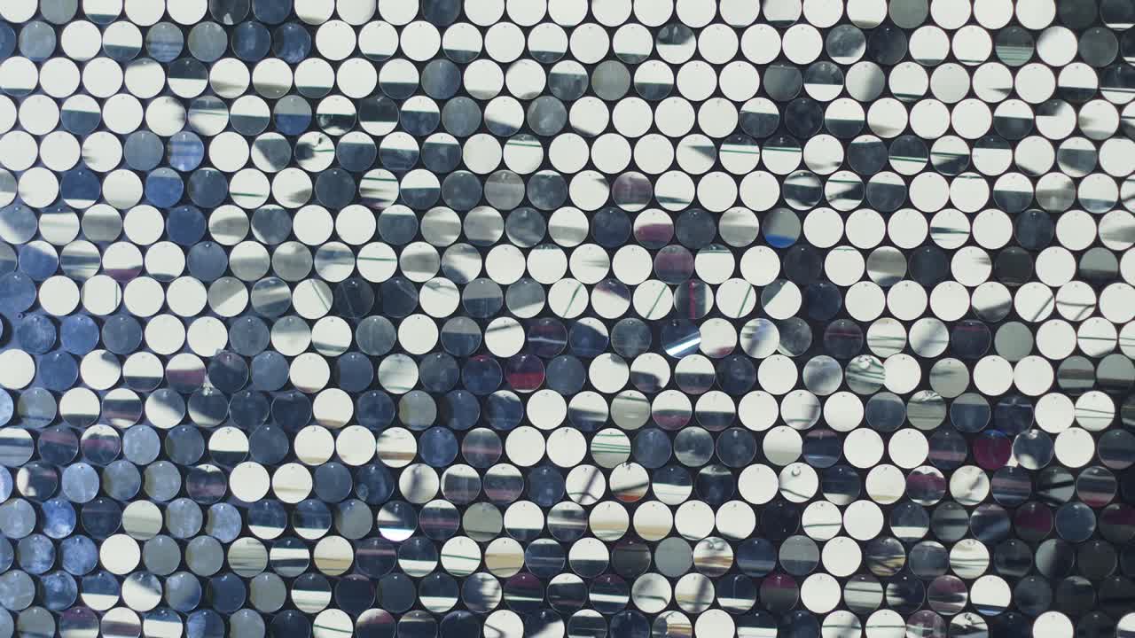 círculos de espejo reflectantes de plástico colgados en la pared y vibrando