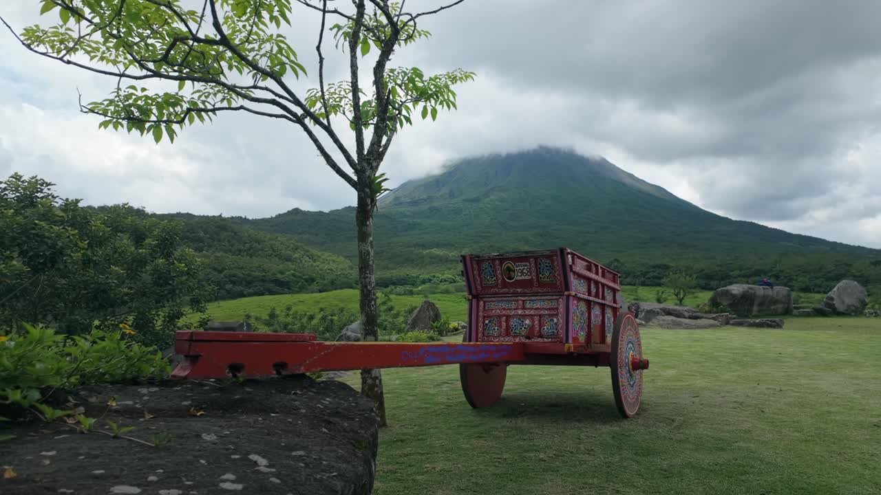 Traditional Costa Rican red-painted cart with national motifs at the foot of Arenal Volcano by the end of the 1968 Trails.