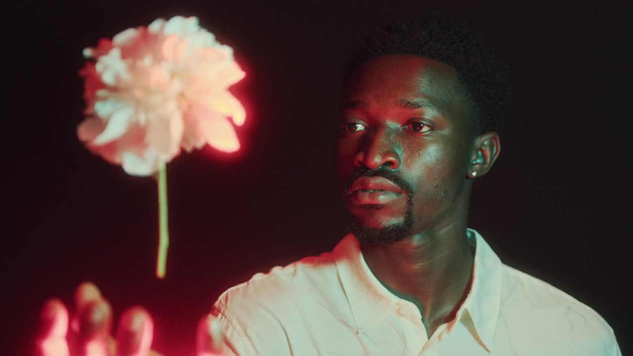 Fascinated Man Watching Flower Levitating and Glowing with Red Light