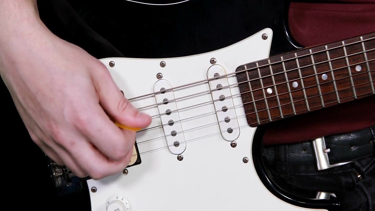 Un chitarrista che pizzica un plettro giallo, generando bolle CTA che si sovrappongono alla chitarra per una promozione musicale.