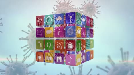 cubo de iconos digitales girando y células de covid-19 flotando contra un fondo gris