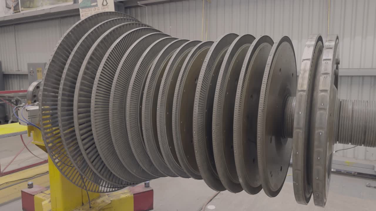 A steam turbine being turned manually in the open air