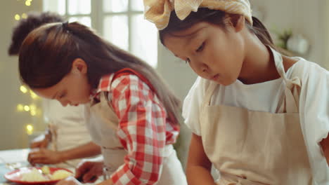 asian girl cutting champignon on culinary lesson