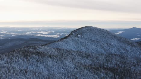 panoramic view of snow-covered mountain peaks of eastern townships quebec canada - right panning aerial shot