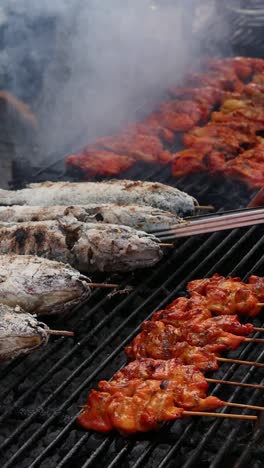 grilling fish and skewers over charcoal flames.