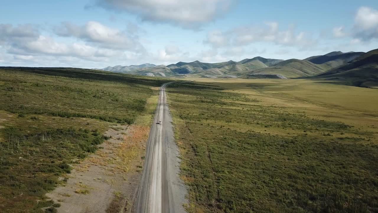 Van driving away on a long remote highway crossing the arctic circle in Northern Canada