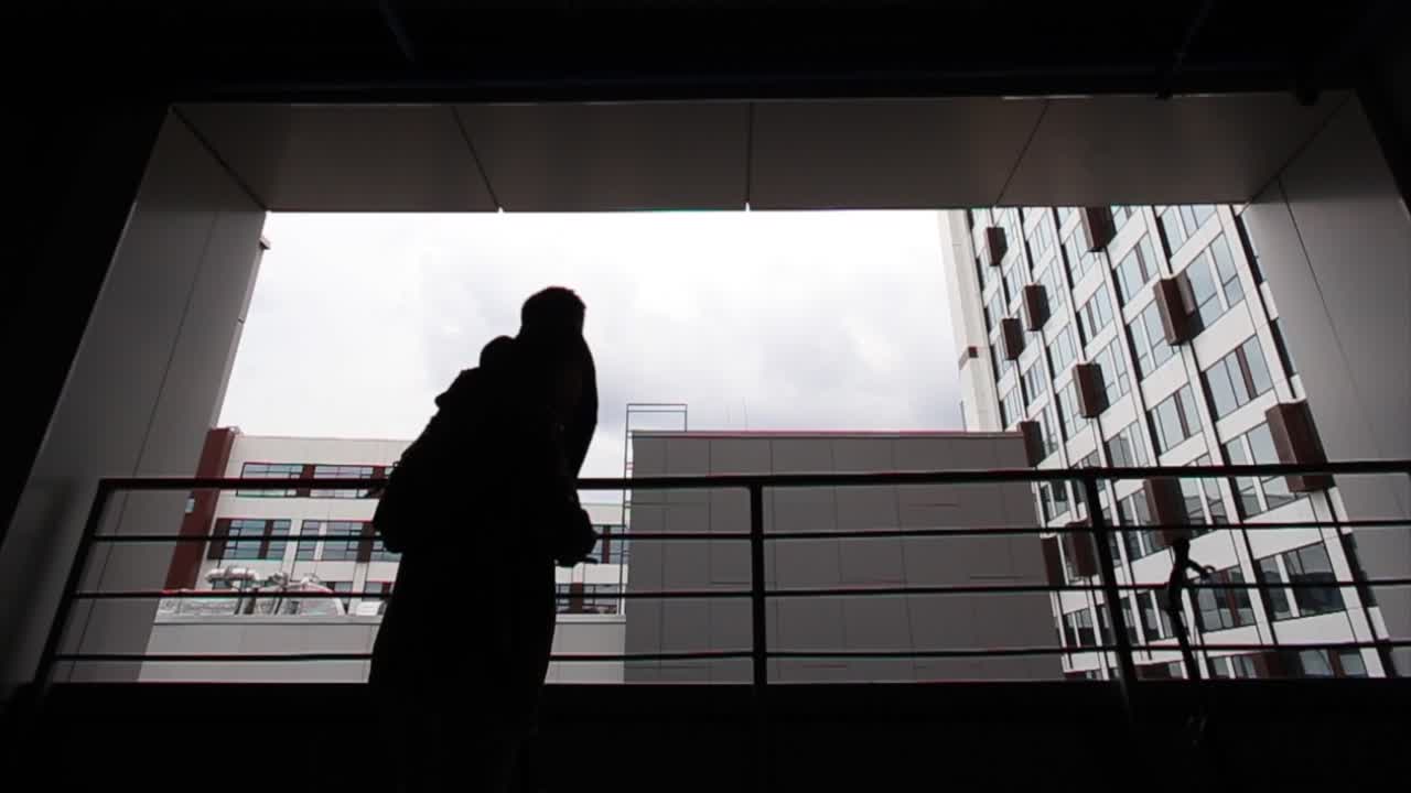 도시 건물을 내려다보는 발코니에 자전거를 타고 있는 두 사람의 실루