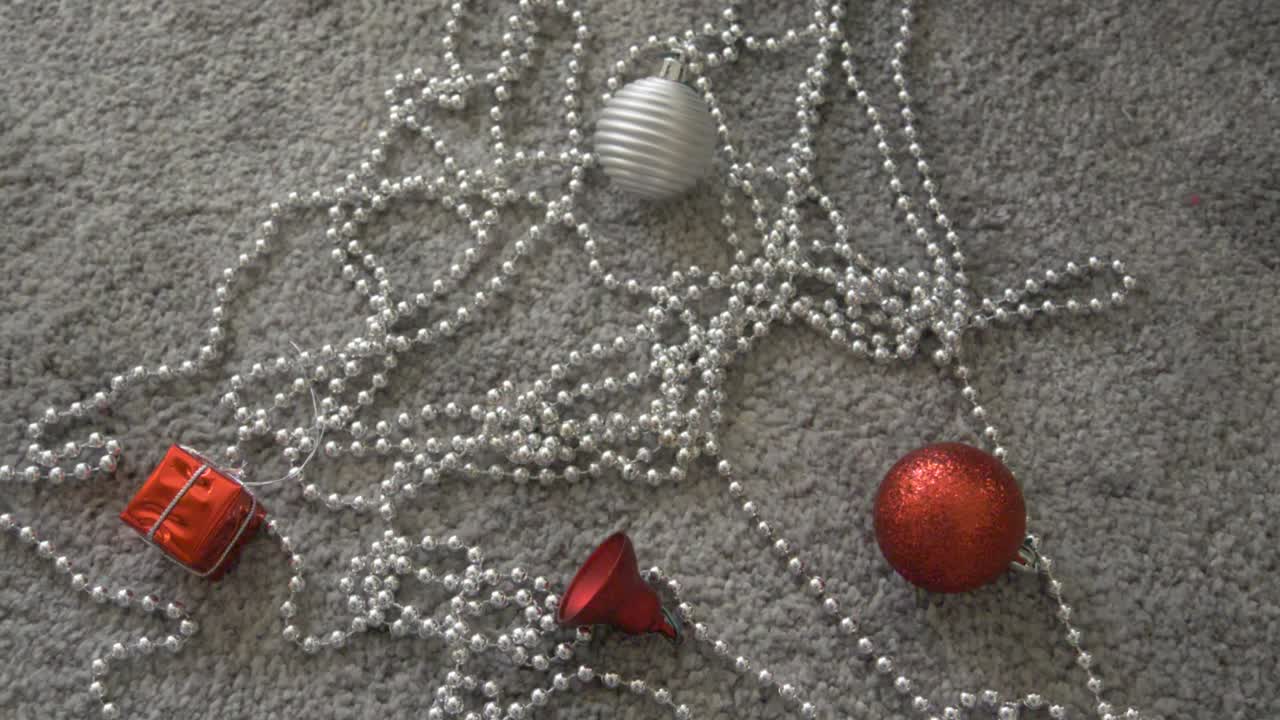 drop a red christmas bauble on the floor with more decorations on the floor