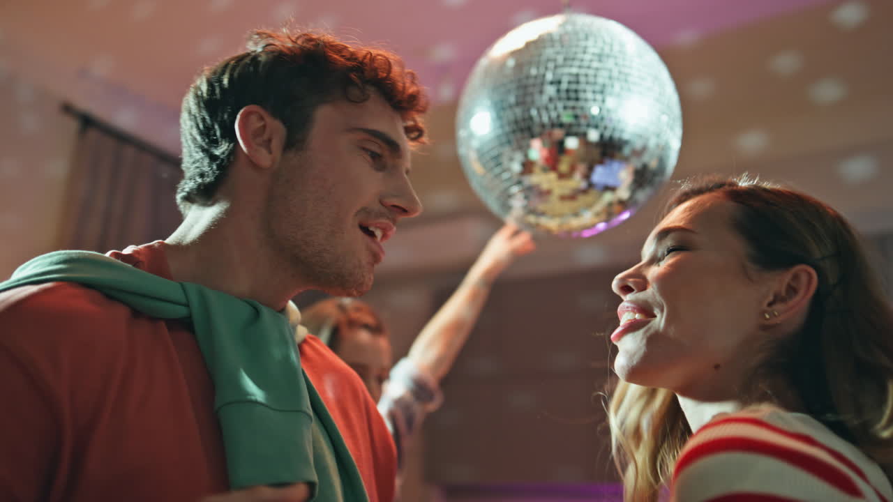 Closeup disco couple dancing together under lights ball. Happy people having fun