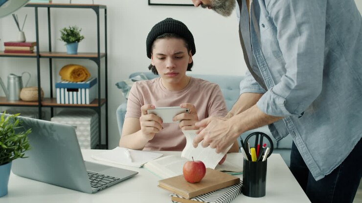Father helping teenage son with homework