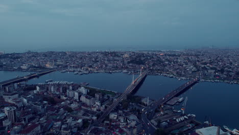 Gloomy-aerial-drone-flight-of-big-river-in-Istanbul-city-with-traffic-on-the-bridges-and-cloudy-sky,-slow-motion-birdseye