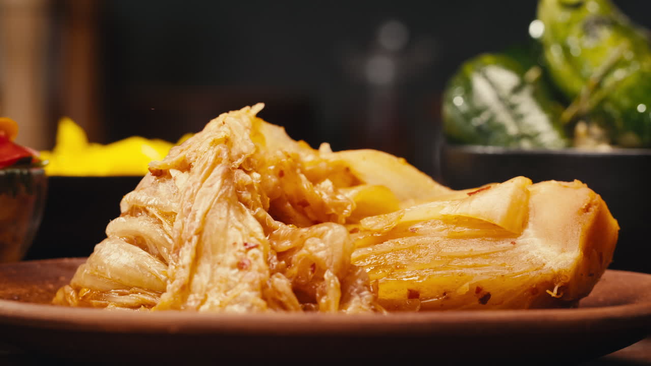 Taking a little bit of fermented spicy cabbage kimchi with chopsticks close-up. Preservation of vegetables in glass jars. Fermentation preserved kimchi cabbage with spices macro. Asian cuisine.