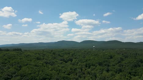 Toma-Aérea-De-Establecimiento-De-Las-Colinas-De-Börzsöny,-Hungría-Con-Una-Esfera-De-Torre-De-Agua-En-El-Bosque