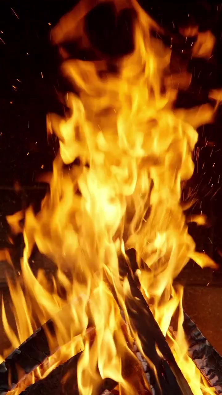 Llamas naranjas vibrantes y chispas en una acogedora chimenea