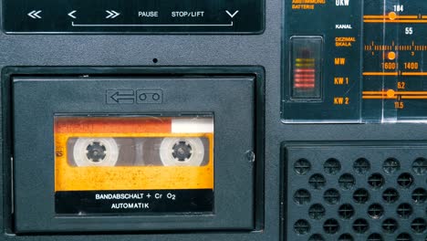 the vintage yellow audio cassette in the old tape recorder rotates