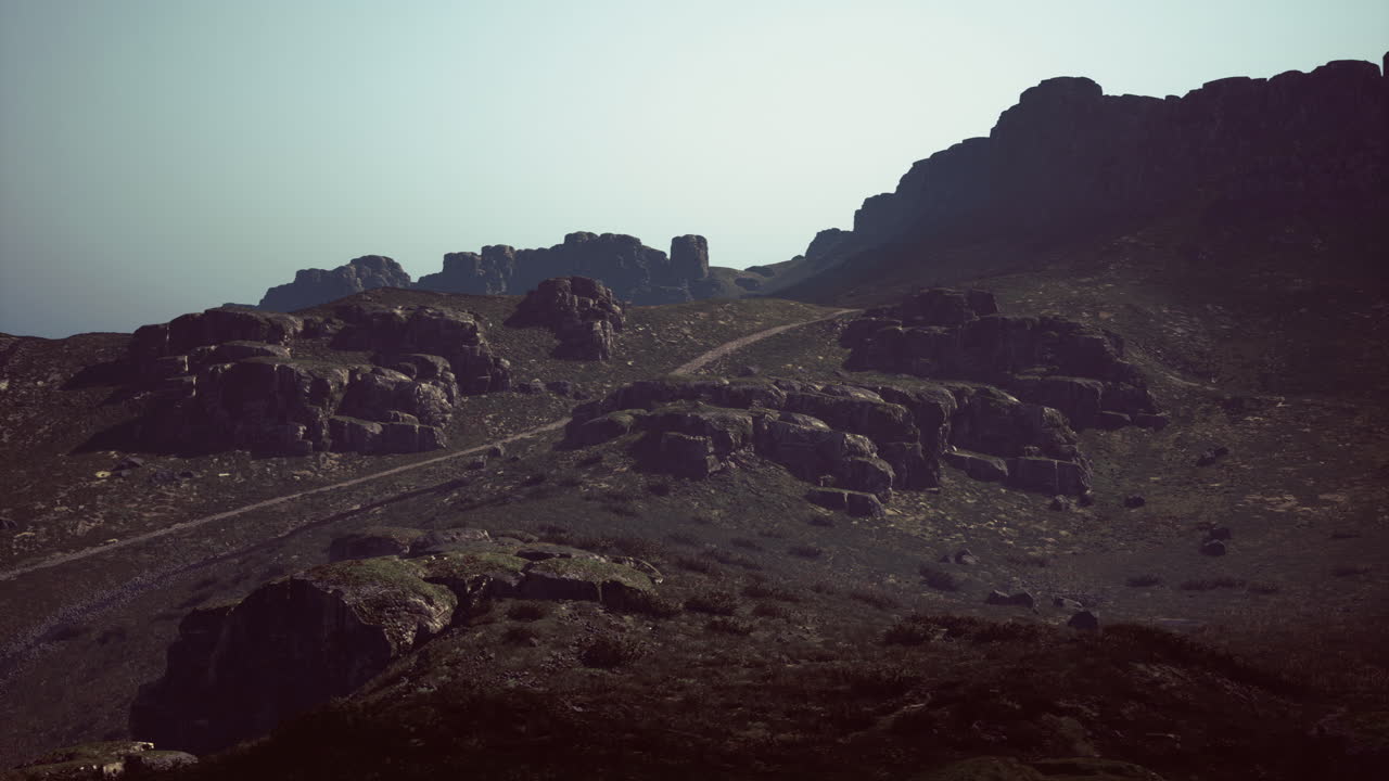 Rocky landscape with winding path under hazy sunlight in the afternoon