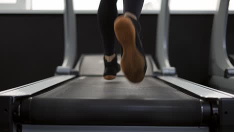 Primer-Plano-De-Piernas-Hombre-Corriendo-En-Cinta-En-El-Gimnasio,-Cámara-Lenta