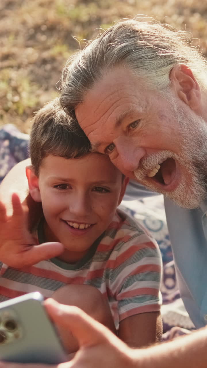 Nonno e nipote che si fanno un selfie insieme all'aperto