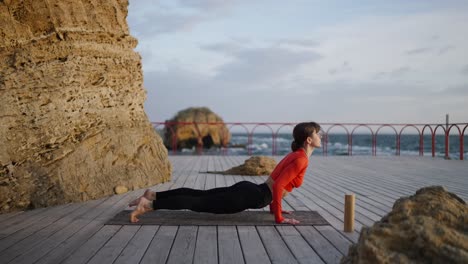 yoga poses on a wooden deck by the ocean