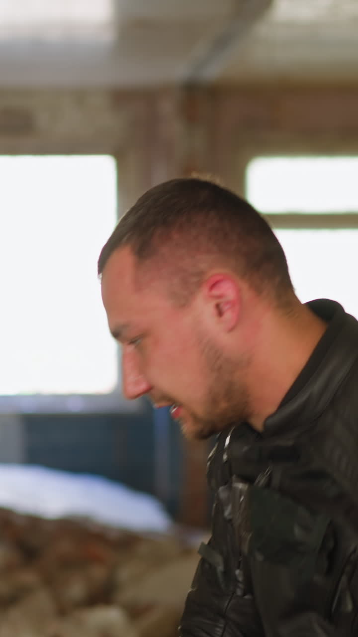 Man takes off moto hardhat from head and plastic bag from young blonde woman saved from criminals in abandoned building closeup slow motion